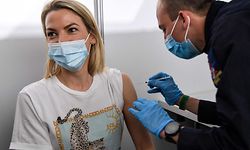 A French red cross member administers a dose of the Pfizer/BioNTech vaccine to a woman at the Covid-19 vaccination center Paris La Defense Arena in Nanterre, west of Paris on the opening day on May 3, 2021. (Photo by BERTRAND GUAY / AFP)