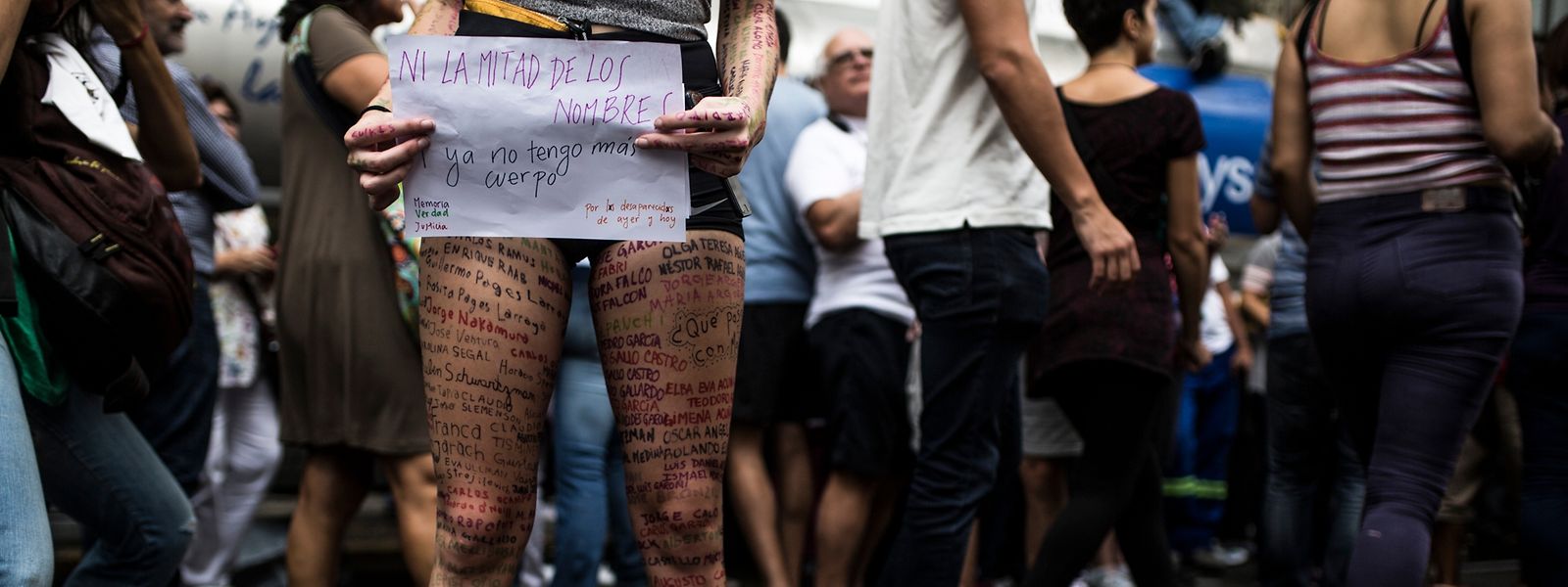 „Das ist nicht mal die Hälfte der Namen (der Verschwundenen)“, steht auf dem Plakat einer  Demonstrantin, die sich die  Namen der Opfer der Diktatur auf die Beine geschrieben hat.  