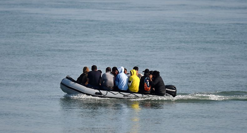 (FILES) In this file photo taken on September 14, 2020 migrants travel by inflatable boat as they reach the shore near Deal on the south east coast of England after crossing the Straits of Dover from France. - Britain has announced it will seek harsher sentences for migrants caught entering the country without permission amid a record-breaking surge in arrivals over the English Channel. The legislation announced July 3, makes it a criminal offence to arrive in the UK without permission, with a maximum sentence for those entering the country unlawfully increasing from six months to four years. (Photo by BEN STANSALL / AFP)