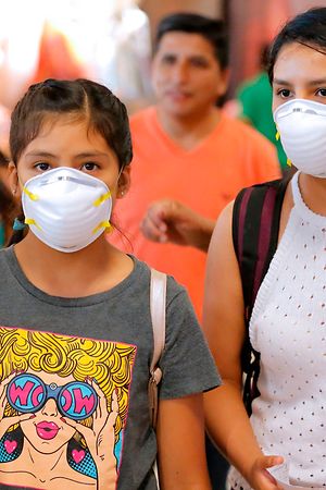 Passengers wear protective face masks as a precaution against the spread of the new Coronavirus, COVID-19, at Jorge Chavez International Airport, in Lima, on March 6, 2020. - Peruvian Government confirmed its first case of Coronavirus. President Martin Vizcarra reported that it is a 25-year-old male patient, who arrived from a trip to Spain, France and the Czech Republic. (Photo by Luka GONZALES / AFP)