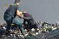 An handout image released by the Spanish Guardia Civil on February 22, 2021 shows a member of the Spanish Guardia Civil discovering an aspiring migrant hidden in a container full of broken glass for recycling  at the port in Spain's Melilla enclave on Morocco's northern coast, on February 19, 2021. - Police discovered a total of 41 migrants at the port trying to illegally board boats to the Spanish mainland on February 19, 2021, hidden in lorries and other vehicles. (Photo by Handout / Spanish Guardia Civil / AFP) / RESTRICTED TO EDITORIAL USE - MANDATORY CREDIT "AFP PHOTO /HANDOUT/SPANISH GUARDIA CIVIL " - NO MARKETING - NO ADVERTISING CAMPAIGNS - DISTRIBUTED AS A SERVICE TO CLIENTS