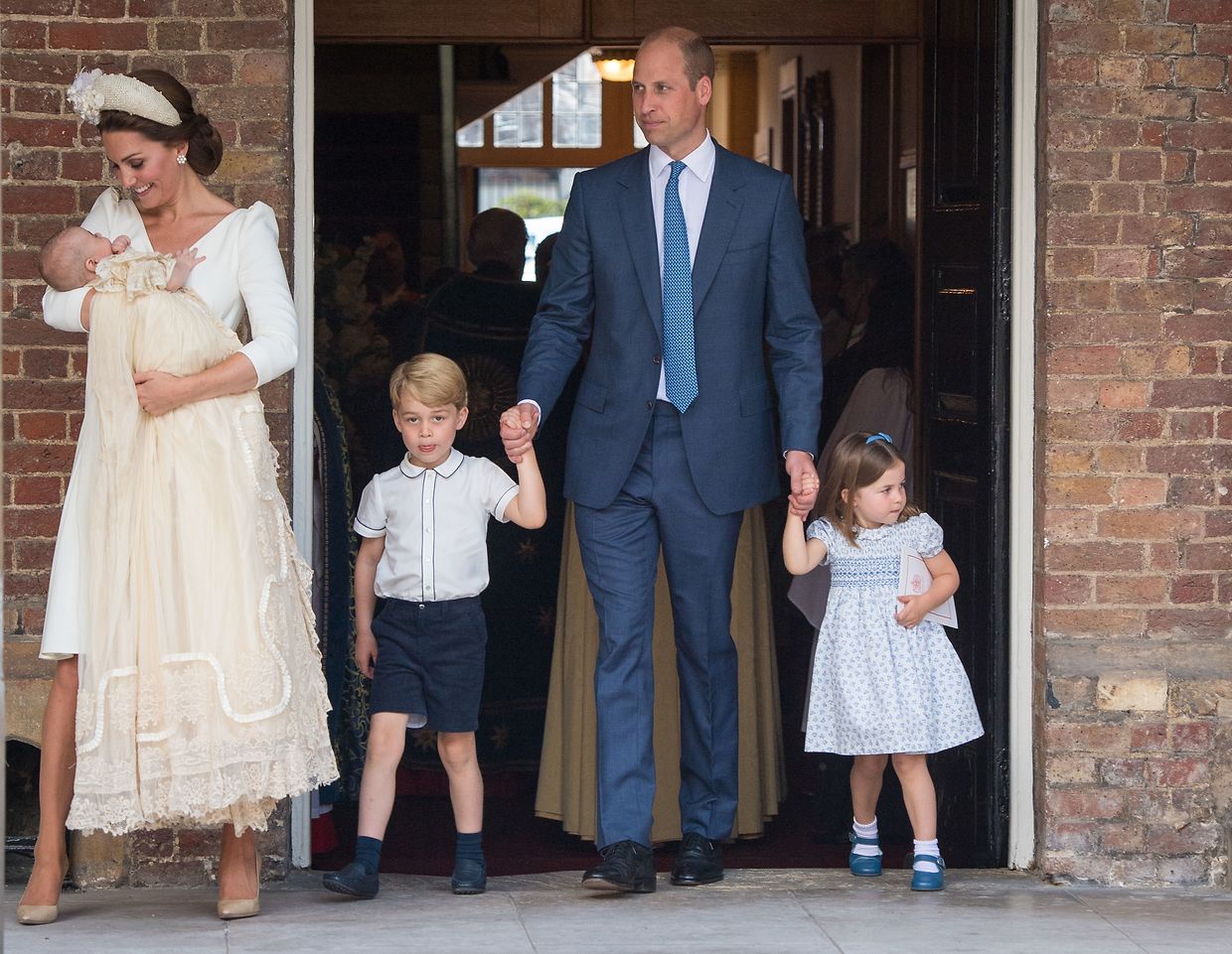 Die britische Herzogin Kate (l) trägt den britischen Prinz Louis, daneben kommen der britische Prinz William (M) mit den beiden Kindern Prinz George (2.v.l) und Prinzessin Charlotte aus der Kapelle des St.-James's-Palastes nach der Taufe von Prinz Louis.