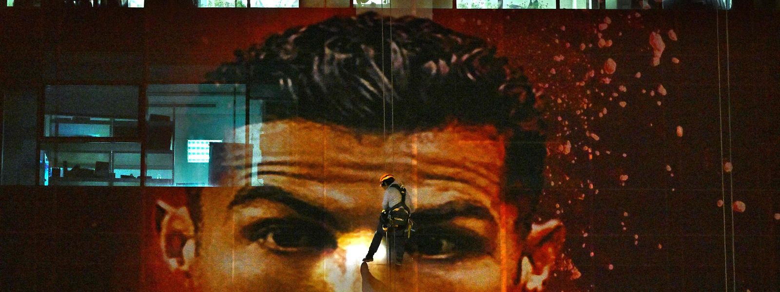 Um trabalhador instala uma imagem gigante de Cristiano Ronaldo num edifício em Doha, a 20 de novembro.
