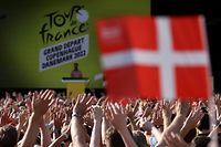 Spectators wave Danish flags as they attend the cycling teams' presentation, two days ahead of the first stage of the 109th edition of the Tour de France cycling race, in Copenhagen, in Denmark, on June 29, 2022. (Photo by Thomas SAMSON / AFP)