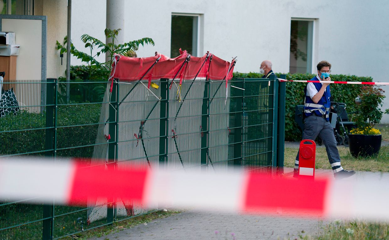 Ein Ersthelfer geht an dem mit einem Sichtschutz versehenen Tatort im Stadtteil Gonsenheim vorbei, wo ein Mann von der Polizei erschossen wurde. 