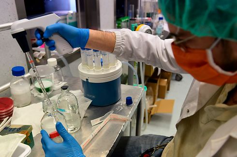 A scientific staff pours a liquid in a little bottle to do the Bioburden test to to evaluate the presence of microbes on surgical masks in an operating room transformed into a laboratory, at the Policlinico Sant'Orsola-Malpighi hospital in Bologna on April 15, 2020. - This laboratory is the only one in Italy that tests protections for medical use according to the European standard. (Photo by Miguel MEDINA / AFP)