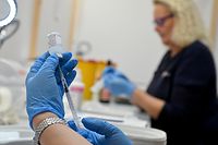 25.11.2021, Bayern, Rosenheim: Eine medizinische Fachangestellte zieht in einer Kabine im Impfzentrum, das in einem Zelt auf dem Loretowiese untergebracht ist, eine Spritze mit dem Impfstoff Moderna auf. Foto: Peter Kneffel/dpa +++ dpa-Bildfunk +++