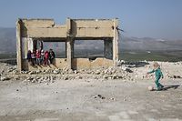 ARCHIV - 23.01.2019, Syrien, Jisr al-Shughur: Kinder spielen in den Trümmern der schwer beschädigten Al-Kefir-Schule. Mehr als 200 Schüler gehen hier immer noch zur Schule, obwohl Angriffe der syrischen Armee hier verheerende Spuren hinterlassen haben. (zu dpa "Bericht: Gezielte Angriffe auf Krankenhäuser und Schulen in Syrien" am 11.05.2020) Foto: Anas Alkharboutli/dpa +++ dpa-Bildfunk +++