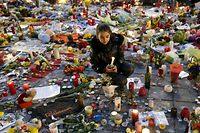 A girl lights a candle as people pay tribute to the victims of Tuesday's bomb attacks at the Place de la Bourse in Brussels, Belgium, March 26, 2016.  REUTERS/Francois Lenoir 