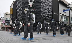 TOPSHOT - South Korean health officials from Bupyeong-gu Office wearing protective gear, spray disinfectants at a shopping district in Incheon on September 17, 2020 amid the new COVID-19 coronavirus pandemic. - South Korea -- which largely overcame an early Covid-19 surge with extensive tracing and testing -- has seen several clusters in recent weeks, raising concerns of a second wave and prompting authorities to tighten social distancing measures last month. (Photo by Jung Yeon-je / AFP)