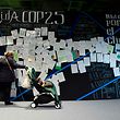 A woman pushes a buggy as she visits an exhibition called "Mothers for the climate" during the UN Climate Change Conference COP25 at the 'IFEMA - Feria de Madrid' exhibition centre, in Madrid, on December 3, 2019. - Spain's Socialist government offered to host this year's UN climate conference, known as COP25, from December 2 to December 13, 2019, after the event's original host Chile withdrew last month due to deadly riots over economic inequality. (Photo by CRISTINA QUICLER / AFP)