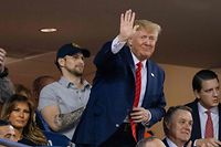 US President Donald Trump (C) waves as US First Lady Melania Trump looks on as they watch Game 5 of the World Series between the Washington Nationals and Houston Astros at Nationals Park in Washington, DC on October 27, 2019. (Photo by TASOS KATOPODIS / AFP)