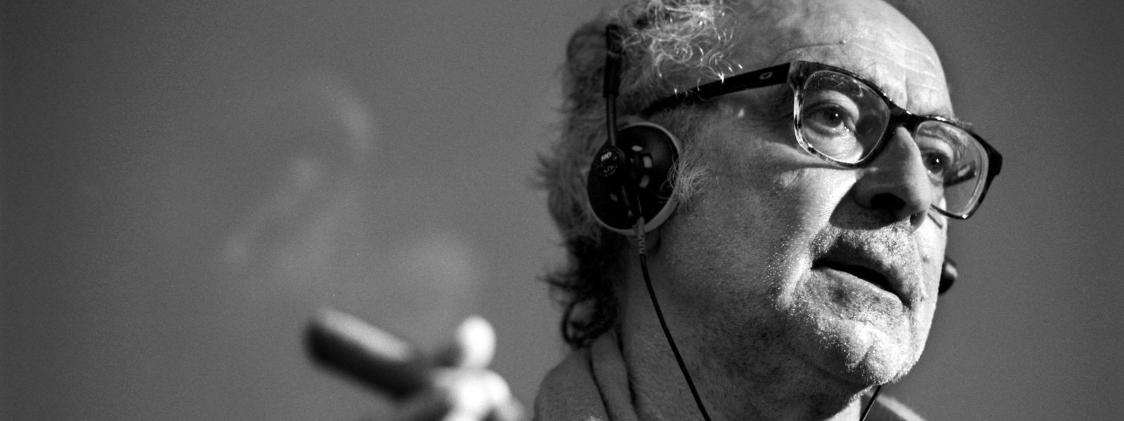 Der Filmregisseur Jean-Luc Godard mit Kopfhörern und Zigarre während eines Filmvortrags an der ETH Zürich. 
