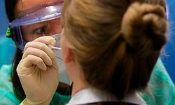 ARCHIV - 03.08.2020, Sachsen, Dresden: Eine Ärztin der Kassenärztlichen Vereinigung Sachsen nimmt in der Corona-Teststation für Urlaubsrückkehrer am Flughafen Dresden International bei einer Frau einen Abstrich für eine Coronavirus-Test. (zu dpa: «Corona-Tests an Sachsens Flughäfen noch bis Ende September») Foto: Robert Michael/dpa-Zentralbild/dpa +++ dpa-Bildfunk +++