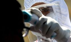 A member of the Red Cross takes the temperature of a man in a car as a preventive measure against the spread of the novel coronavirus, COVID-19, on the Guadalajara-Morelia highway, Jalisco State, Mexico, on May 2, 2020. (Photo by Ulises RUIZ / AFP)