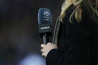 (FILES) In this file photograph taken on December 19, 2015, a journalist holds a microphone with the logo of French first football division Ligue 1 and Canal Plus television broadcaster before the French L1 football match between Caen (SM Caen) and Paris Saint-Germain (PSG) at The Michel d'Ornano stadium, in Caen, north-western France. - The Professional Football League (LFP) and its broadcasters Canal+ and beIN Sports announced April 24, 2020, an agreement for the payment of TV rights for L1 and L2 matches already played, which they had refused to pay until then. (Photo by Charly TRIBALLEAU / AFP)