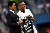 Paris Saint-Germain's French forward Kylian Mbappe (R) poses with PSG president Nasser Al-Khelaifi (L) after the announcement he staying at PSG until 2025 before the French L1 football match between Paris Saint-Germain (PSG) and Metz at the Parc des Princes stadium in Paris on May 21, 2022. (Photo by Anne-Christine POUJOULAT / AFP)