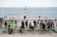 People practice sport near the beach of Barcelona, on May 9, 2021. - Spain has lifted a state of emergency in place since October to fight the pandemic, allowing Spaniards to travel between regions for the first time in months. (Photo by Josep LAGO / AFP)