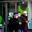 Tourists wear protective face masks as they walk in the centre of Brussels near a closed shop, on March 14, 2020, amid the outbreak of COVID-19, caused by the novel coronavirus. - Belgium close schools, cancel all cultural events and shutter bars and restaurants to stave off the spread of the coronavirus outbreak.  Beginning on March 14, only stores that provide essential services -- such as pharmacies and grocery stores-- will remain open under normal conditions. (Photo by Kenzo TRIBOUILLARD / AFP)