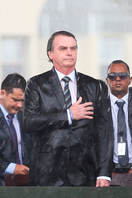 Jair Bolsonaro, Präsident von Brasilien, steht unter dem Regen mit einer Hand auf dem Herzen während einer Militärveranstaltung. Im Streit über den richtigen Umgang mit dem Coronavirus entließ Bolsonaro den beliebten Gesundheitsminister Mandetta, der eine strenge Linie verfolgt hatte. Kurz darauf trat auch der Justizminister Moro zurück.