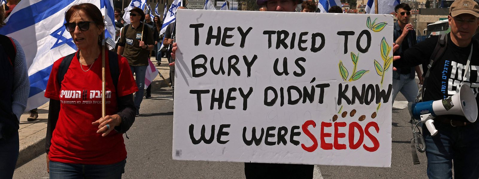Proteste gegen geplante Justizreform vor dem Parlament in Tel Aviv: Auf dem Plakat eines Demonstranten steht auf Englisch: „Sie haben versucht, uns zu begraben. Sie wussten nicht, dass wir Saatgut sind.“