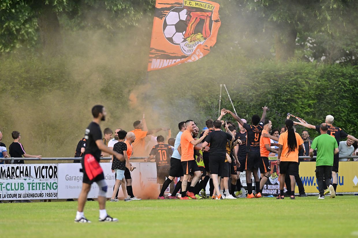 Die Anhänger des FC Minière Lasauvage feiern mit ihren Spielern.