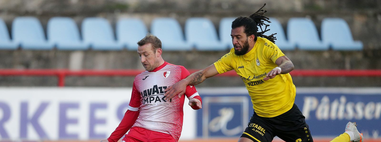 Nelito da Cruz, do Dudelange, disputa a bola com Dominik Stolz, do Hesperange. 