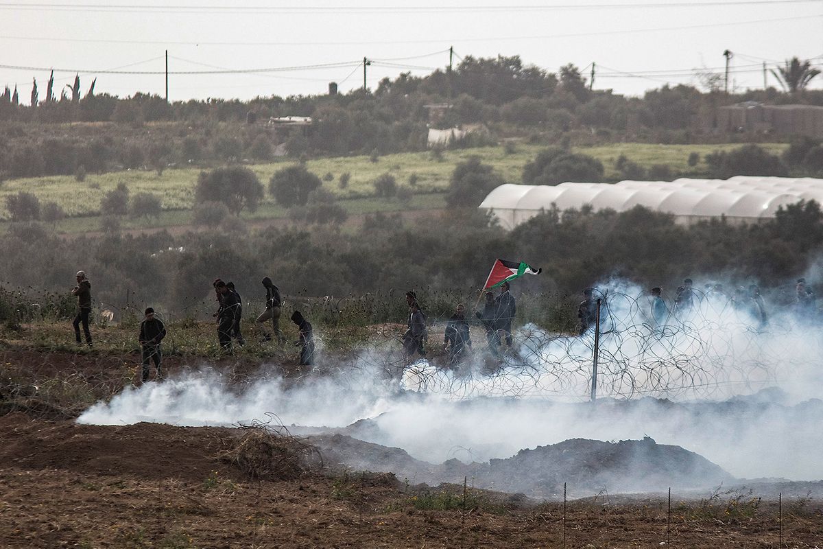 Ein Foto von der israelischen Seite der israelisch-palästinensischen Grenze im Gazastreifen zeigt palästinensische Demonstranten, die inmitten von Tränengas stehen, das von den israelischen Streitkräften während der Zusammenstöße am ersten Jahrestag der Proteste zum Großen Marsch der Rückkehr abgefeuert wurde.