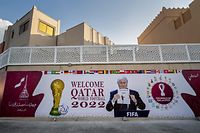 A picture of former FIFA president Joseph Blatter opening the envelope to reveal that Qatar would host the 2022 World Cup on December 2, 2010, is depicted on a giant banner in a crossroad in Doha on November 18, 2022, ahead of the Qatar 2022 World Cup football tournament. (Photo by FABRICE COFFRINI / AFP)
