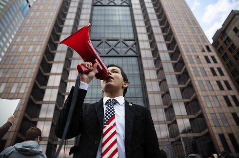 A protester yells into a megaphone at a rally at the Ohio State House in Columbus, Ohio on April 18, 2020, to protest the stay home order that is in effect until May 1st. (Photo by Megan JELINGER / AFP)