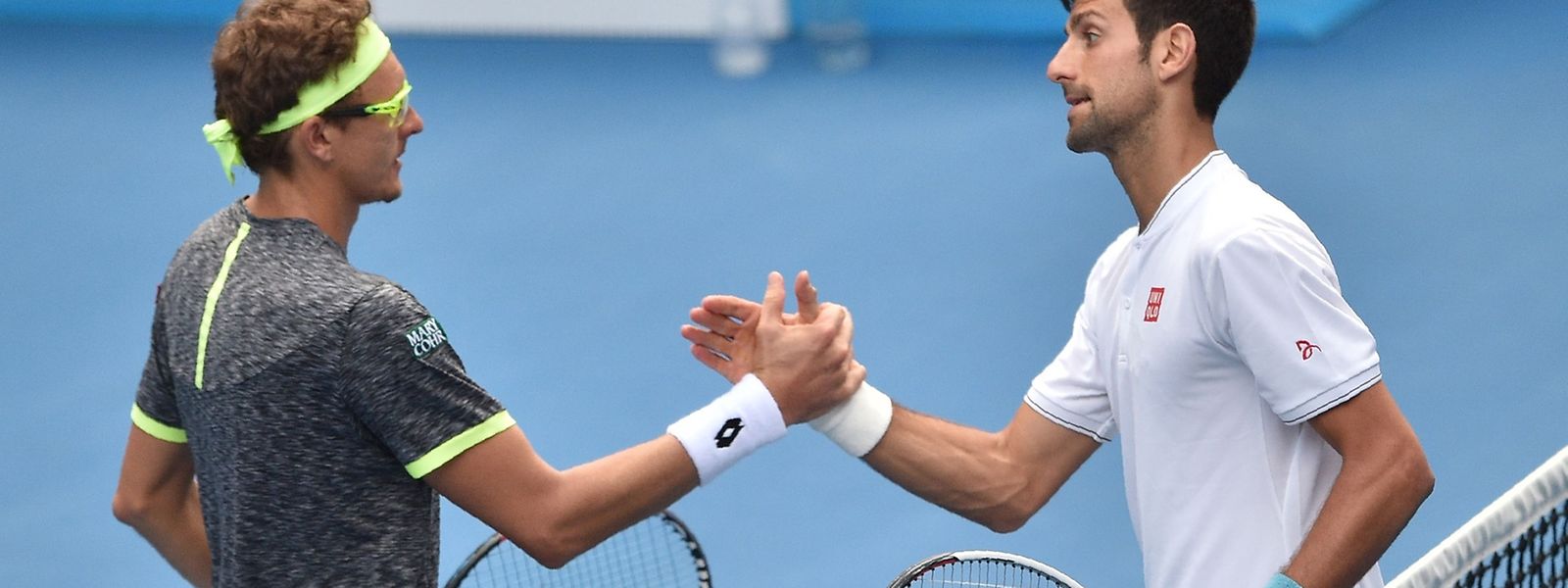  Novak Djokovic (à dta.)  foi eliminado pelo uzbeque Denis Istomin (à esq.)