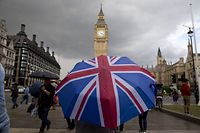 (FILES) In this file photo taken on June 25, 2016 A pedestrian shelters from the rain beneath a Union flag themed umbrella as they walk near the Big Ben clock face and the Elizabeth Tower at the Houses of Parliament in central London on June 25, 2016, following the pro-Brexit result of the UK's EU referendum vote. - The European Union and Britain could agree the terms of a post-Brexit trade deal within hours, European sources told AFP on December 23, 2020, as negotiations continued. (Photo by JUSTIN TALLIS / AFP)
