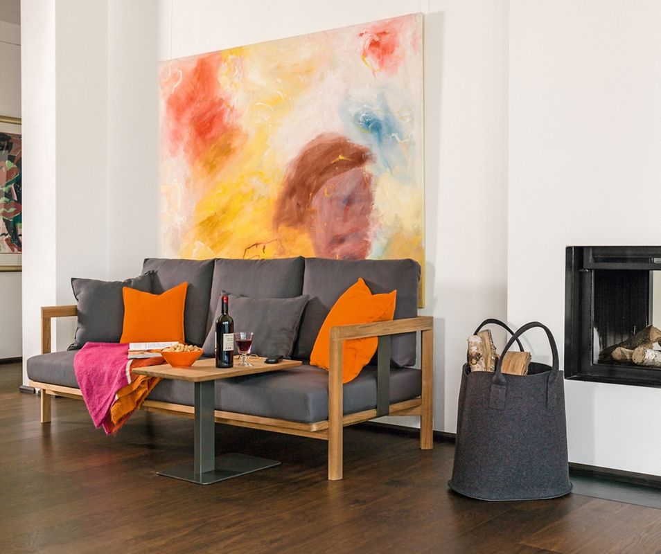 Ein Sofa mit Holzrahmen, ein Kamin, gemütliches Ambiente - der Landhausstil hat viele Gesichter und auch moderne Züge