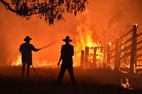 (FILES) In this file photo taken on November 12, 2019 residents defend a property from a bushfire at Hillsville near Taree, 350km north of Sydney. - Earth Day is an annual event on April 22 to demonstrate support for environmental protection. (Photo by PETER PARKS / AFP)