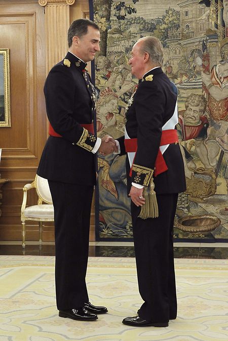 Juan Carlos (r), ehemaliger König von Spanien, begrüßt 2014 seinen Sohn Felipe VI., König von Spanien, nachdem er ihm die Schärpe des Feldmarschalls während einer Zeremonie im Zarzuela-Palast übergeben hat. 