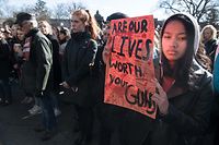 TOPSHOT - A student holds a sign at Georgetown University in Washington, DC, on March 14, 2018 during a national walkout to protest gun violence, one month after the school shooting in Parkland, Florida, in which 17 people were killed. / AFP PHOTO / NICHOLAS KAMM