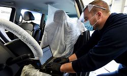 A mechanic wearing a visor and a mask uses his computer to diagnose a breakdown on a car which has been previously disinfected at a Peugeot car dealership, on May 4, 2020, in Illiers-Combray, central France, as the country is on lockdown to stop the spread of the COVID-19 caused by the novel coronavirus. - Sebastien and Celine Ringuede, owners of the car dealership which has remained open to service the cars of medical staff, have brought their employees back to work. A strict protocol has been established by the automobile company to avoid any risk of contamination. The car is left with the key in the ignition lock and the windows are left open by the customer. The mechanic, wearing a protective mask and visor, takes care of the car, disinfects the driving position, covers the driver's seat and the steering wheel. (Photo by JEAN-FRANCOIS MONIER / AFP)