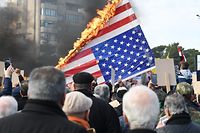 Syrian demonstrators burn the US flag as they gather in the central Saadallah al-Jabiri square in the northern Syrian city of Aleppo on January 7, 2020, to mourn and condemn the death of Iranian military commander Qasem Soleimani, and nine others in a US air strike in Baghdad. (Photo by - / AFP)