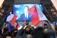 Supporters react after the victory of French President and La Republique en Marche (LREM) party candidate for re-election Emmanuel Macron in France's presidential election, at the Champ de Mars, in Paris, on April 24, 2022. (Photo by bERTRAND GUAY / AFP)