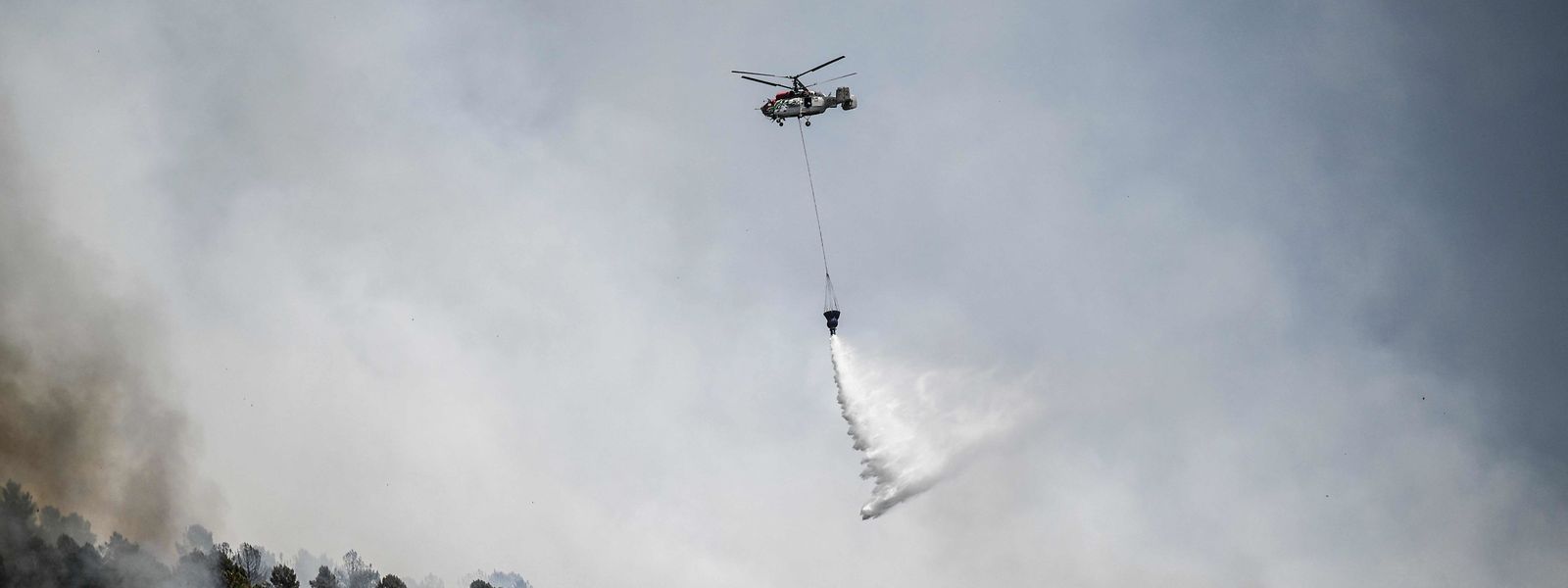 Um helicóptero efetua descarga de água sobre uma floresta na aldeia de Sameiro, perto da vila de Manteigas, a 10 de agosto