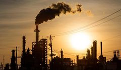 TOPSHOT - The sun sets behind smoke rising from the LyondellBasell-Houston Refining plant in Houston, Texas, on April 20, 2020. - US oil prices crashed to unprecedented lows on April 20 as futures in New York ended in negative territory for the first time amid a devastating supply glut that has forced traders to pay others to take the crude off their hands. (Photo by Mark Felix / AFP)