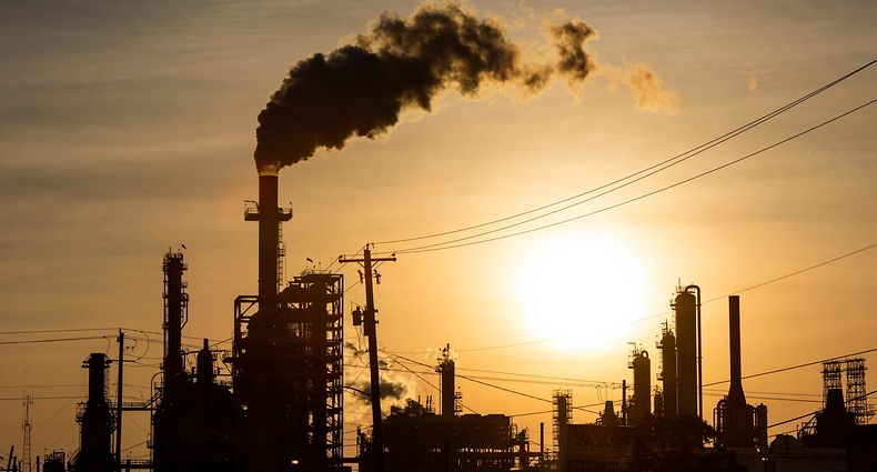 TOPSHOT - The sun sets behind smoke rising from the LyondellBasell-Houston Refining plant in Houston, Texas, on April 20, 2020. - US oil prices crashed to unprecedented lows on April 20 as futures in New York ended in negative territory for the first time amid a devastating supply glut that has forced traders to pay others to take the crude off their hands. (Photo by Mark Felix / AFP)