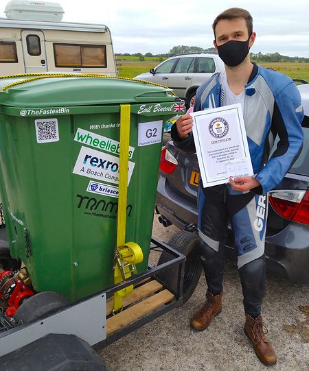Andy Jennings, Konstrukteur aus Großbritannien, hält nach einem Weltrekordversuch mit einer motorisierten Mülltonne (l) eine Urkunde in der Hand. Der 28-Jährige hat auf dem Flugplatz von Elvington in North Yorkshire den Rekord für die schnellste motorisierte Mülltonne aufgestellt. 