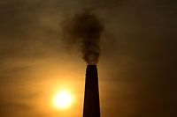 (FILES) In this file photo taken on March 15, 2023, smoke billows from a brick factory chimney on the outskirts of Prayagraj. - UN Secretary General Antonio Guterres called on wealthy countries on March 20, 2023, to move up their goals of achieving carbon neutrality as close as possible to 2040, mostly from 2050 now, in order to "defuse the climate time bomb." (Photo by SANJAY KANOJIA / AFP)