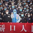 Members of a medical assistance team from Jiangsu province chant slogans at a ceremony marking their departure after helping with the COVID-19 coronavirus recovery effort, in Wuhan, in China's central Hubei province on March 19, 2020. - Medical teams from across China began leaving Wuhan this week after the number of new coronavirus infections dropped. China on March 19 reported no new domestic cases of the coronavirus for the first time since it started recording them in January, but recorded a spike in infections from abroad. (Photo by STR / AFP) / China OUT