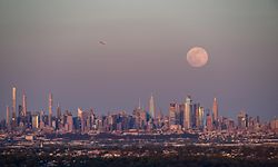 The full moon of April, called the Super Pink Moon, rises over the skyline of Manhattan on April 26, 2021. (Photo by Angela Weiss / AFP)
