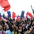 TOPSHOT - Supporters of French presidential election candidate for the En Marche ! movement Emmanuel Macron wave French national flags as they celebrate in front of the Pyramid at the Louvre Museum in Paris on May 7, 2017, following the announcement of the results of the second round of the French presidential election.
Emmanuel Macron was elected French president on May 7, 2017 in a resounding victory over far-right Front National (FN - National Front) rival after a deeply divisive campaign, initial estimates showed. / AFP PHOTO / Eric FEFERBERG
