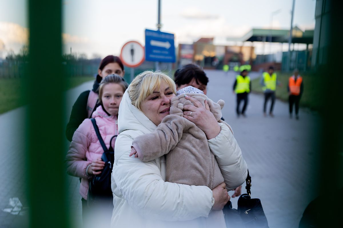 A woman holds her grandson at the Polish border