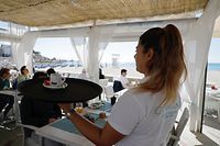 24.04.2022, Spanien, Calvia: Eine Servicekraft serviert einen Kaffee im Restaurant Can Blanc am Strand von Palmanova auf der Urlaubsinsel Mallorca am Strand. Auf Mallorca beginnt die Hochsaison Anfang Mai. Foto: Clara Margais/dpa +++ dpa-Bildfunk +++