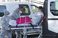 Paramedics load a patient on a strechter into a ambulance at The Emile Muller Hospital Emergencies in Mulhouse, eastern France, on March 24, 2020, on the eighth day of a strict lockdown in France to stop the spread of the novel coronavirus. (Photo by SEBASTIEN BOZON / AFP)